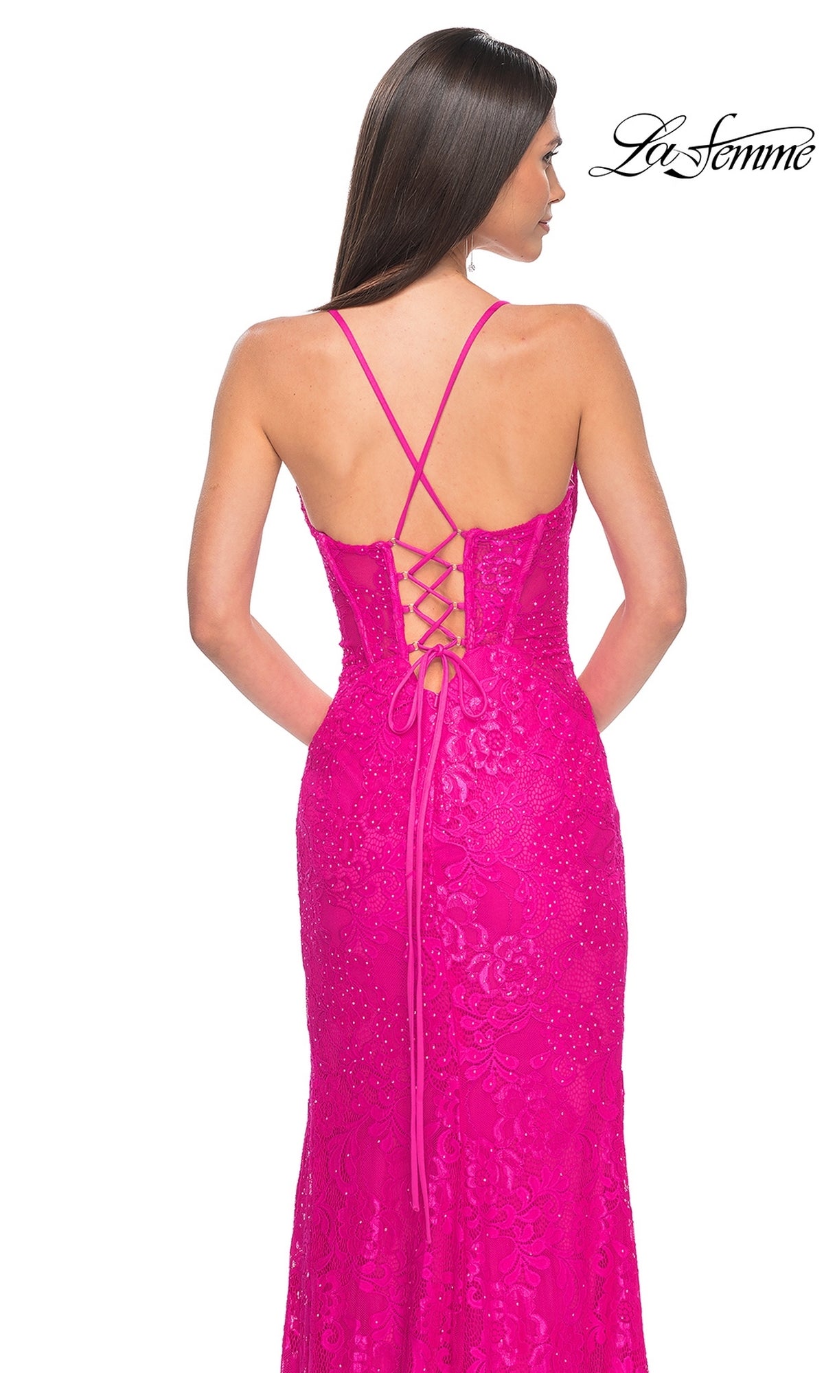 A woman faces away in the La Femme Floral-Lace Long Corset Prom Dress 32248—bright pink, sleeveless, with a lace-up back and fitted bodice. The La Femme logo is shown in the upper right corner.